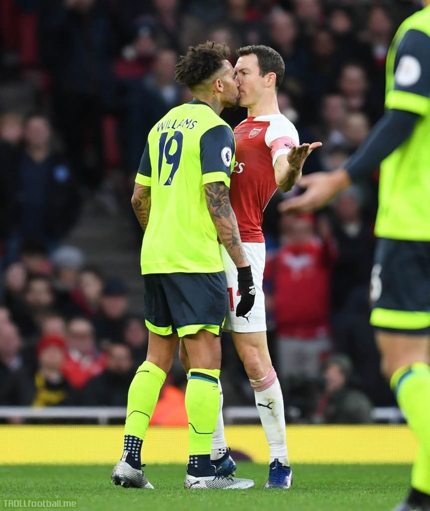Danny Williams planting a kiss on Stephan Lichtsteiner during today's match between Arsenal and Huddersfield Town